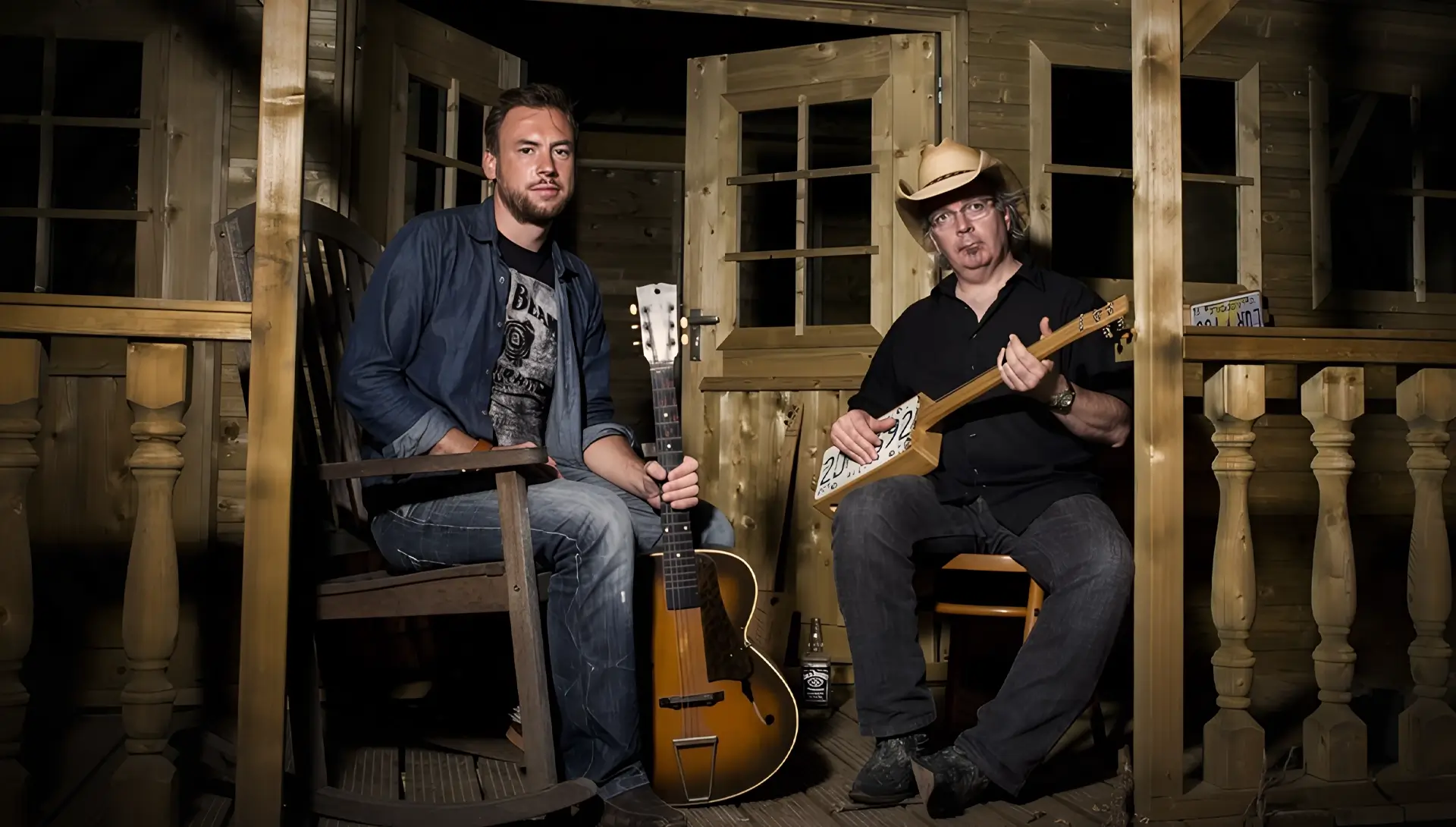 Gumbo & The Monk poseren met gitaren en een zelfgebouwde cigar box guitar in een houten, intieme setting, voorafgaand aan hun optreden tijdens Red Light Jazz.