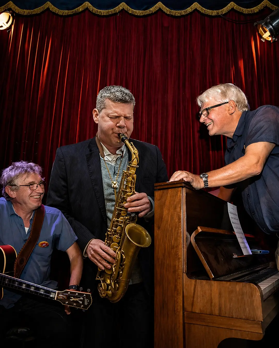 Jazz musicians Berend van den Berg (piano), Joep Lumeij (guitar/double bass) and Marco Kegel (saxophone) performing together in an intimate setting during Red Light Jazz Festival.