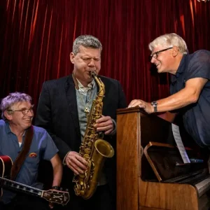 Jazz musicians Berend van den Berg (piano), Joep Lumeij (guitar/double bass) and Marco Kegel (saxophone) performing together in an intimate setting during Red Light Jazz Festival.