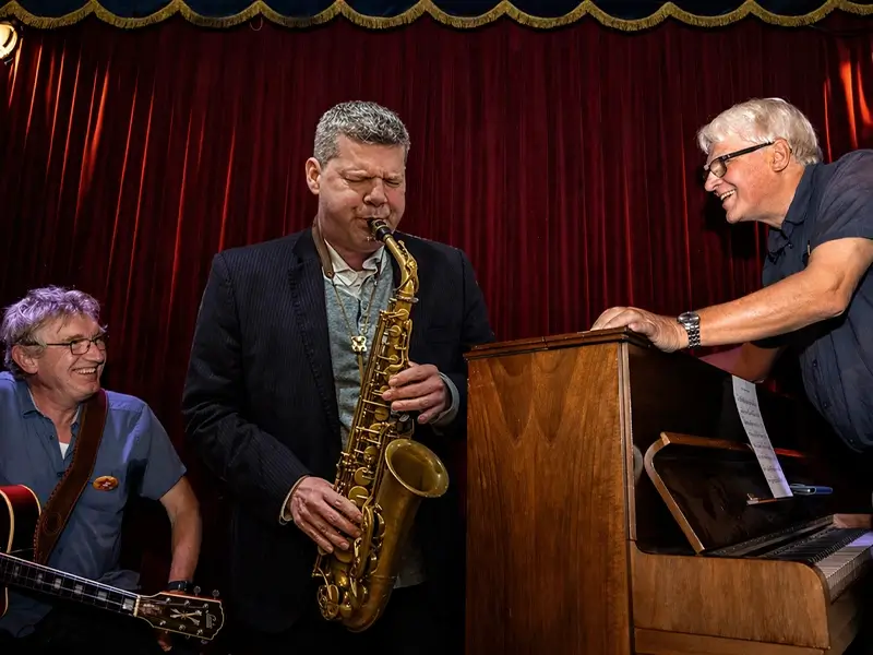 Jazz musicians Berend van den Berg (piano), Joep Lumeij (guitar/double bass) and Marco Kegel (saxophone) performing together in an intimate setting during Red Light Jazz Festival.