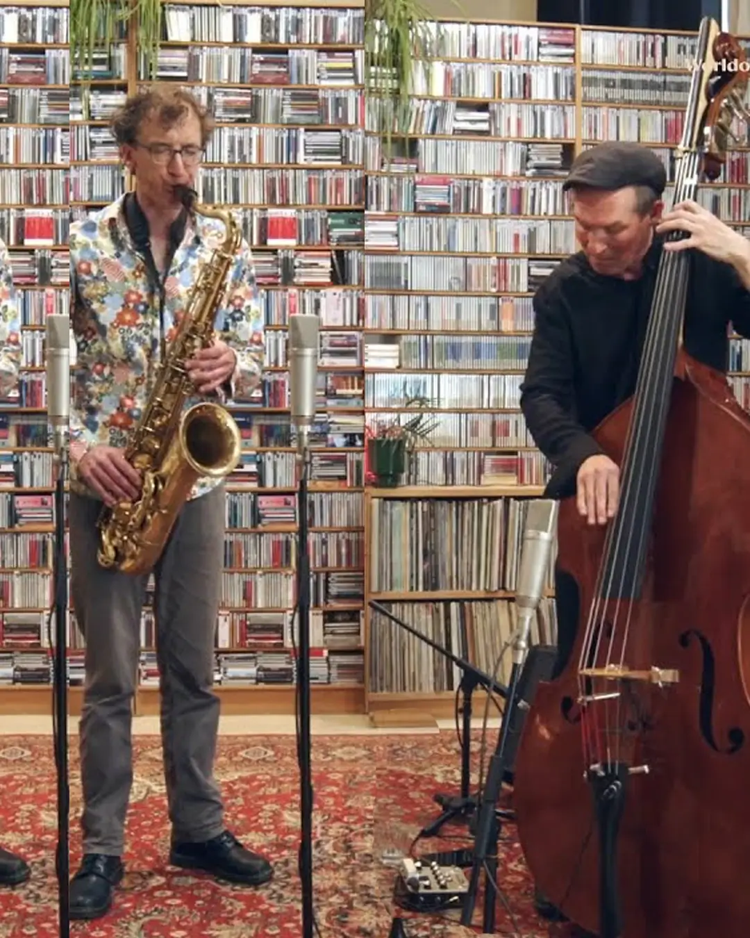 Een saxofonist en een contrabassist spelen een akoestisch jazzduo in een intieme ruimte, met een grote wand vol cd’s op de achtergrond en microfoons opgesteld voor hen.