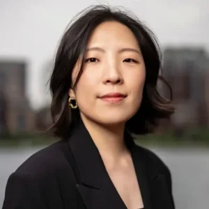 Zwart-wit portret van jazzpianiste Miran Noh, frontaal kijkend, met een rustige en zelfverzekerde uitstraling tegen een zacht vervaagde stedelijke achtergrond