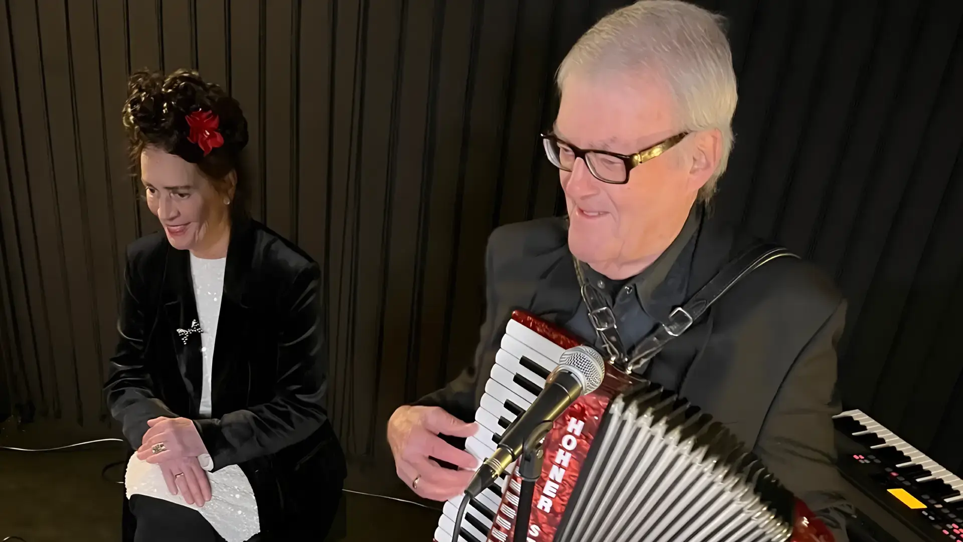 Clous van Mechelen speelt piano en saxofoon tijdens een intiem optreden in een cafésetting.