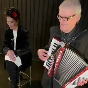Clous van Mechelen speelt piano en saxofoon tijdens een intiem optreden in een cafésetting.