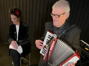 Clous van Mechelen speelt piano en saxofoon tijdens een intiem optreden in een cafésetting.