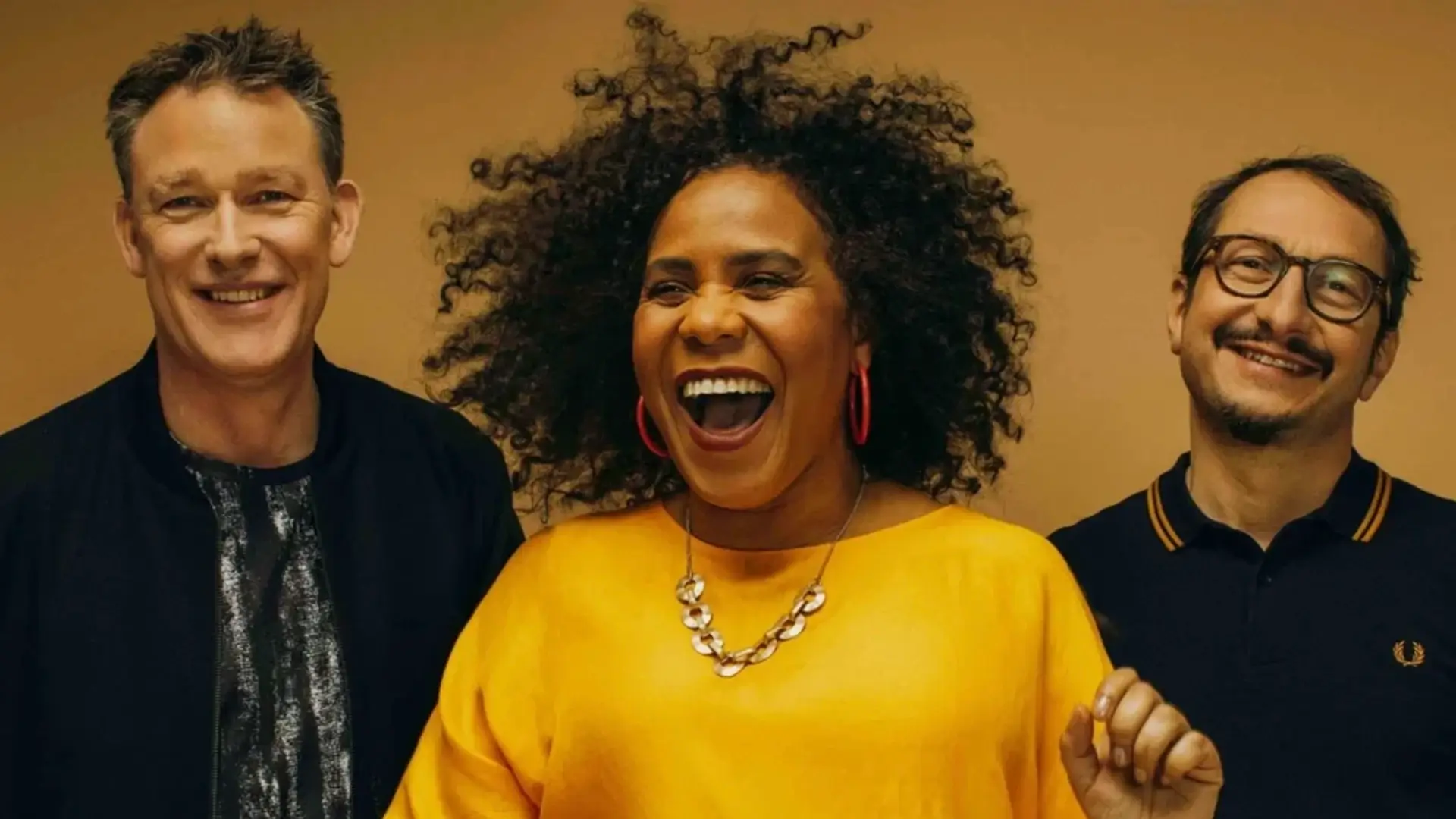 Zuco 103 bandfoto met zangeres Lilian Vieira en bandleden in warme gele setting