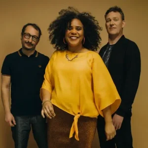 Zuco 103 bandfoto met zangeres Lilian Vieira en bandleden in warme gele setting