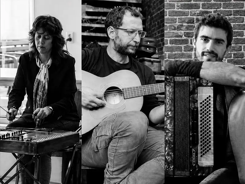 Een kleine band speelt Griekse jazz en rembetika met gitaar, accordeon en cimbaal, in een intieme setting.