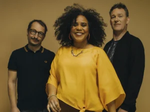 Zuco 103 bandfoto met zangeres Lilian Vieira en bandleden in warme gele setting