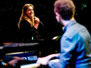 Anna Sollewijn zingt terwijl Chris Müller piano speelt tijdens een live optreden.