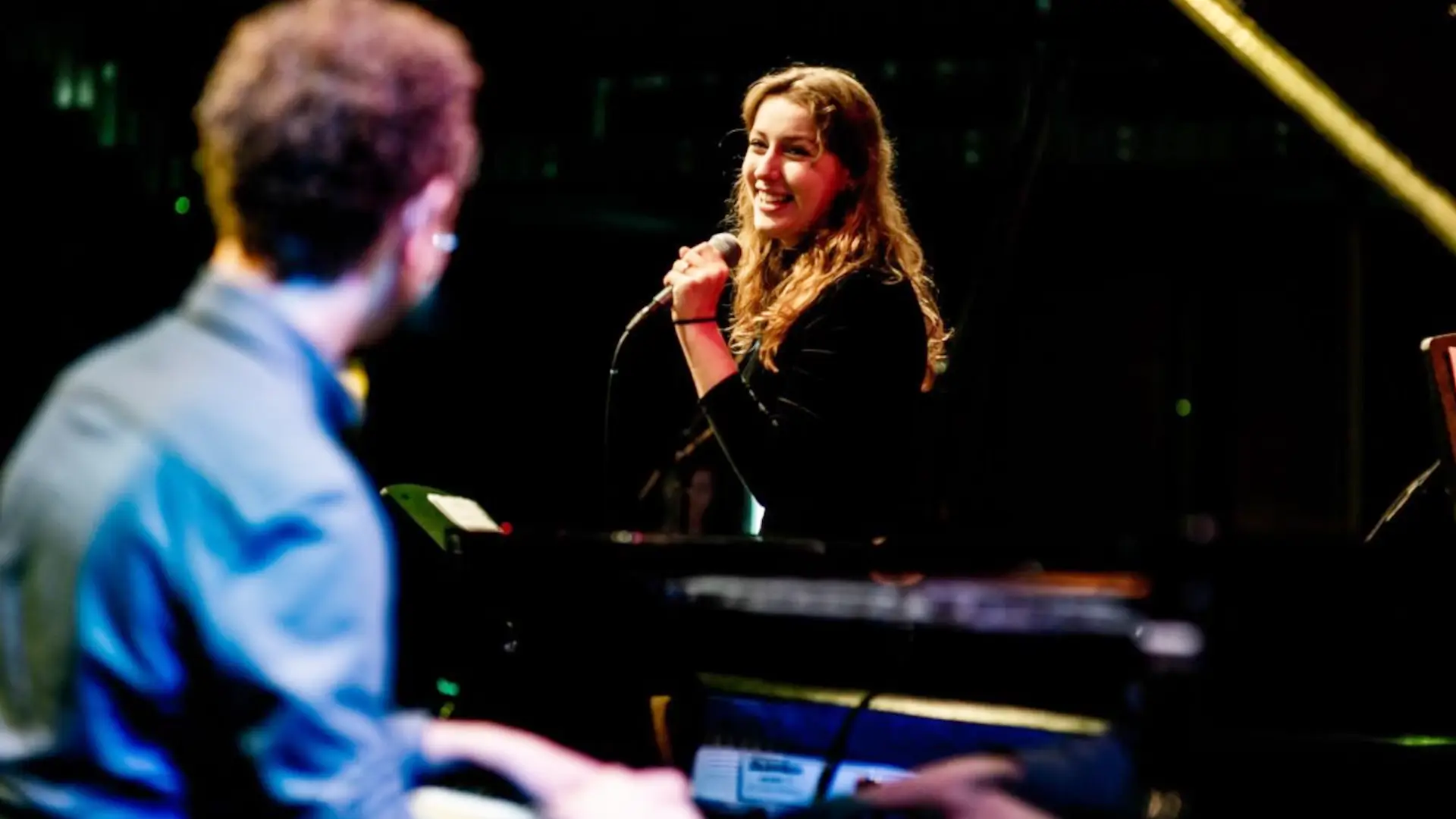 Anna Sollewijn zingt terwijl Chris Müller piano speelt tijdens een live optreden.