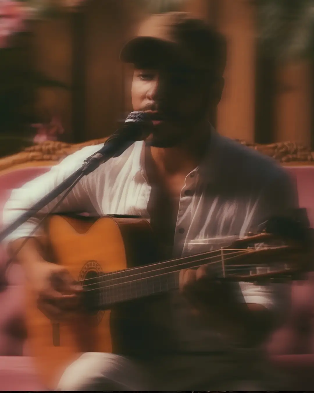 Zanger en gitarist Fernando Oliveira zingt in een warme, sfeervolle setting in de microfoon tijdens een intieme live performance.