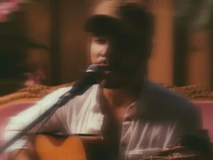 Zanger en gitarist Fernando Oliveira zingt in een warme, sfeervolle setting in de microfoon tijdens een intieme live performance.